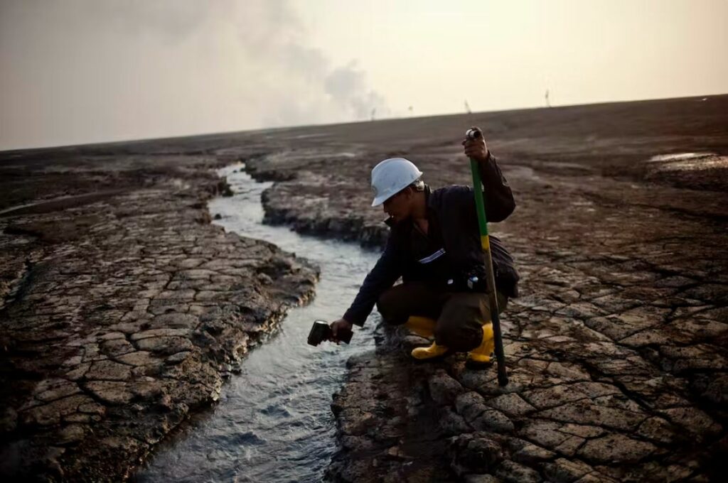 Um oficial da Agência de Prevenção de Lama de Sidoarjo verifica a temperatura da água da lama perto do vulcão de lama Lusi em 2011. Fonte: Ulet Ifansasti/Getty Images.